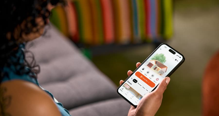 Person utilizing the HomeView tool in the Vivint app to find insights into automation, security, and energy usage.
